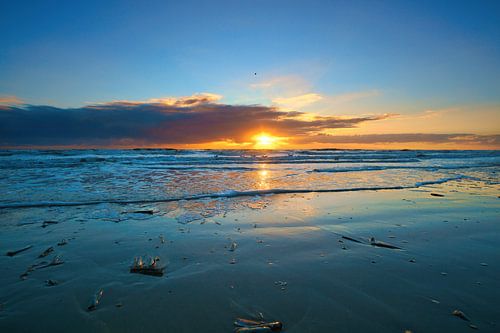 Op het strand van Blåvand bij zonsondergang aan zee