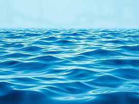 Tiefblaue Gelassenheit: Eine weite Fläche mit ruhigen Ozeanwellen unter einem dunstigen Himmel