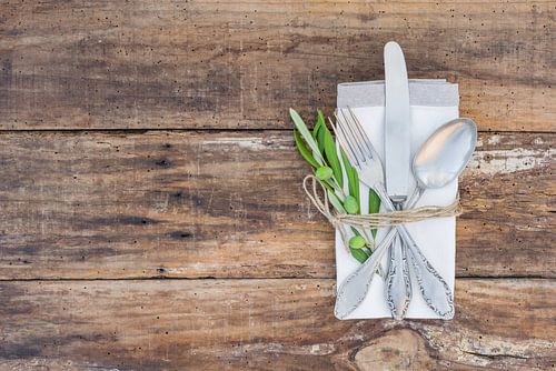 Mediterrane tafel setting met bestek, servet op olijven tak decoratie