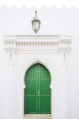 Groene deur met lantaarn in Asilah in Marokko