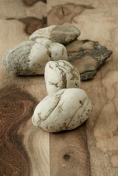 Stilleben mit weißen Steinen auf beige-braunem Holz von Alie Ekkelenkamp