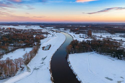 De Vecht stroomt door een besneeuwd winterlandschap bij zonsopgang