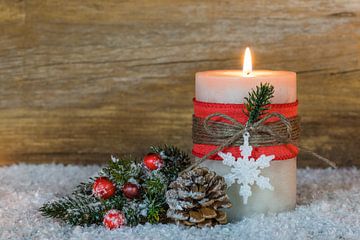 Weihnachts- und Adventskerze verziert mit Schneeflocken-Ornament auf Schnee von Alex Winter