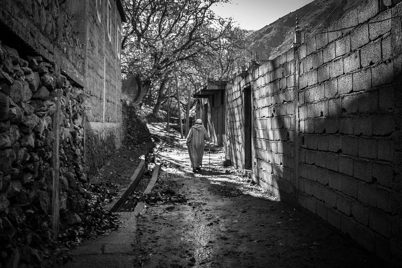 Berber man walking through the village van Dick Hooijschuur