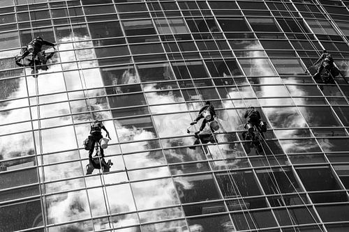 Window cleaners hang from rope as they scrub the windows of a glass skyscraper in Buenos Aires