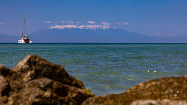 A sailing boat with Mount Olympus in the distance at Simantro Beach by Alexander Wolff