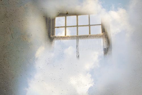 Hemels uitzicht - oud raam met blauwe hemel en wolken
