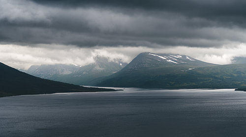 A dramatic landscape overlooking Lake Gjevillvatnet, with the Gjevilvasskamman shrouded in mist