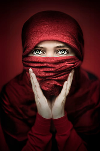 Desert Rose – Porträt einer Frau mit rotem Schleier und grünen Augen