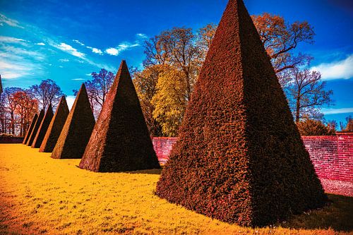Zeven puntige piramides in zonnige gekleurde tuin