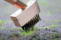 Enlever la mousse et les mauvaises herbes de la chaussée.