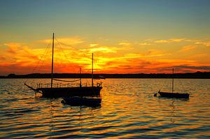 Landschaftsbild: Segelboote auf dem See im Sonnenuntergang