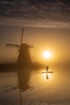 SUP-per in mistige zonsopkomst bij Kinderdijk van Frank Laurens