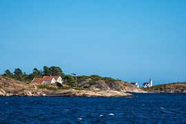 Rocky coast and lighthouse Hamborsund Fyr in Norway by Rico Ködder