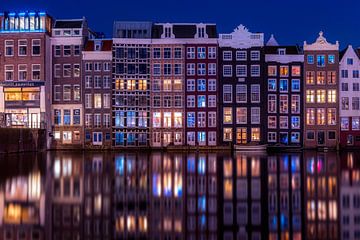 Grachtenhäuser auf dem Damrak in Amsterdam während der blauen Stunde