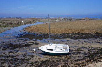Segelboot am Strand bei Ebbe in der Bretagne