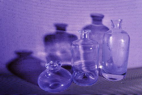 Blauwe flessen met schaduw in stilleven