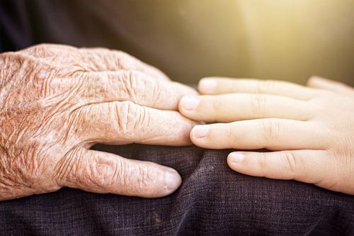 Une jeune main touche une main plus âgée
