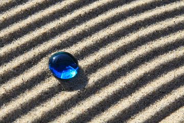 Pierre de verre bleue sur des lignes de sable sur Karina Baumgart