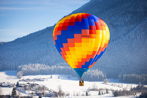 Een heteluchtballon boven een besneeuwd Inzell in Duitsland