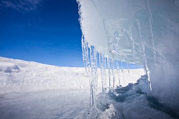 Mysterieuze ijsgrot, of ijsgolf hangt als ijspegels over het ijs van het Baikalmeer, blauwe lucht van Michael Semenov