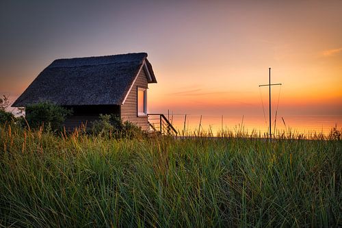 Huis met rieten dak aan het strand van de Oostzee
