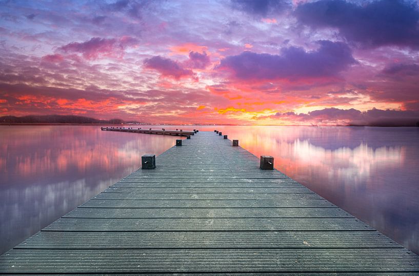 Setting sun around a lake with a jetty by RICHARD Degenhart