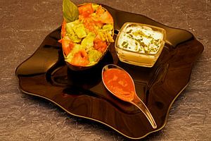 Frischer Salat in Avocadoschalen auf schwarzem Teller serviert