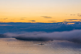 Inseln im Schärengarten mit Nebel und Sonnenaufgang vor Stockholm, Schweden.