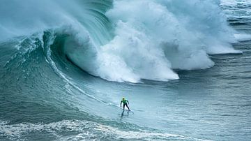 Surfers in de golven van Nazaré in Portugal