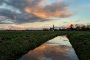 De stad IJlst in Friesland met op de voorgrond een spiegeling van de lucht in een sloot. One2expose 