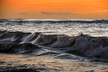 De branding bij zonsondergang. van Gonnie van de Schans