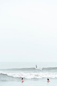 Lustiger Moment von zwei Schwimmern und einem Surfer in der winterlichen Nordsee
