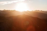 Warme Lichtstrahlen über Berggipfeln in den österreichischen Alpen. Lens Flares von Hidde Hageman Miniaturansicht