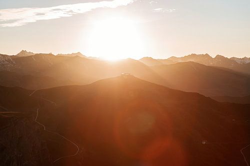 Warme lichtstralen over bergtoppen in de oostenrijkse alpen. Lens flares van Hidde Hageman