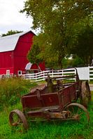 Red barn with rusty machine in foreground