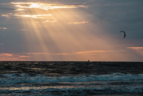 Dunkle Wellen, beleuchtet von goldorangenen Sonnenstrahlen