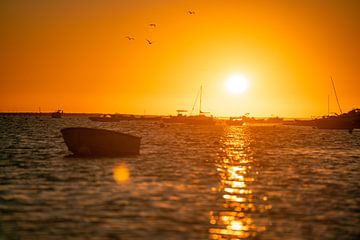 Sonnenaufgang an der Küste der Algarve mit Booten und dem glitzerndem Meer