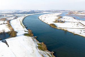Die IJssel fließt durch eine verschneite Winterlandschaft