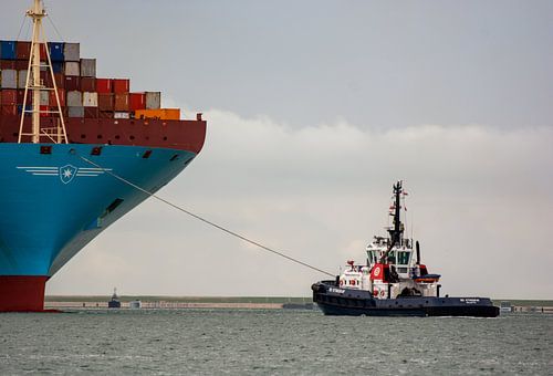 Sleper aan de boeg van een machtig Containerschip.