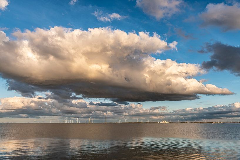 Wind farm on the IJsselmeer with storm clouds. by Brian Morgan