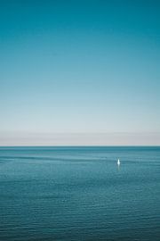 Minimalist image of ocean and a lone side boat by Lizet Wesselman