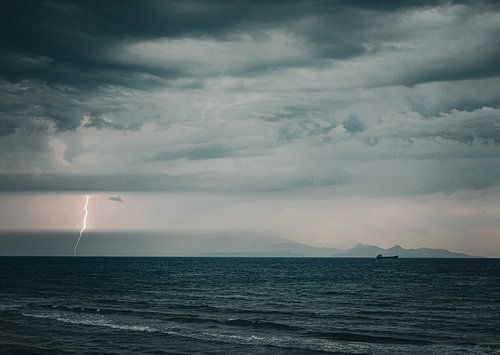 Vue sur la mer et les montagnes avec des éclairs