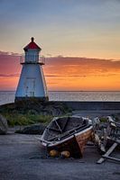 Zonsondergang met ondersteunde boot bij de vuurtoren op Vigra, Noorwegen