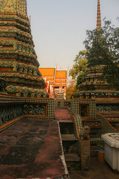 Second sidewalk view to ornate roof, flanked from parts of Chedis at Wat Pho.