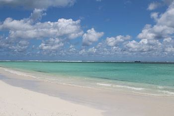 Zeezicht op turquoise water en wit zand