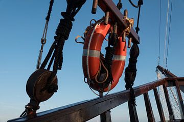 un vieux bateau en bois avec une bouée de sauvetage rouge