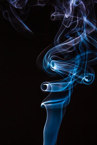 Blauwe en paarse wierook op een zwarte achtergrond.