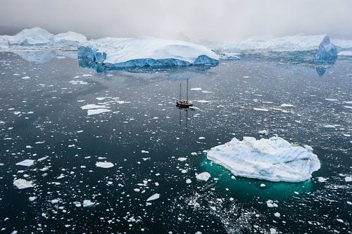 Sailing boat between ice floes in Greenland