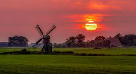 Mill landscape in the red setting sun by piet douma
